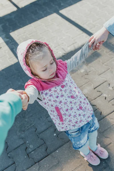 Beyaz saçlı küçük bir Avrupalı kız şehirde dolaşıyor. 