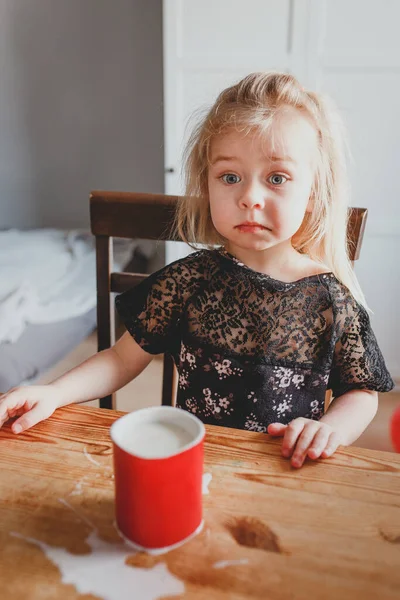 Una Piccola Ragazza Bionda Siede Tavola Durante Giorno Casa — Foto Stock