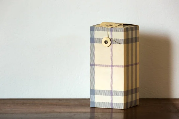 Beyaz arkaplan ile ahşap bir masa üzerinde kapalı bir hediye gibi mavi çizgili güzel temiz kutu.