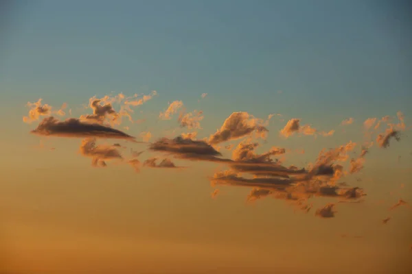 Gün batımında turuncu ve mavi gökyüzünde turuncu bulutlar. Pastel renkler. Ufku olmayan gökyüzü. Metin için boş boşluk.