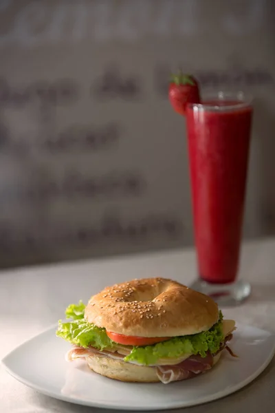 Jambonlu ve peynirli sandviç ve çilek suyu. Yemek fotoğrafçılığı.