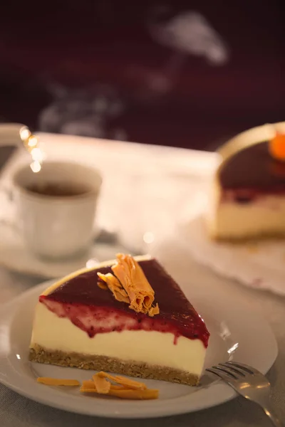Çilek soslu ve portakallı cheesecake porsiyonuna yakın çekim. Çay dolduruyorum. Çay evi..