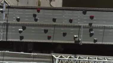 Yazın şehir merkezinde, otoyoldaki köprüden arabalar geçer. Yukarıdan helikopterin üst görüntüsü.