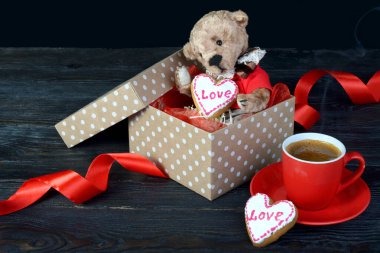 Hediye kutusunda kalbi olan güzel bir oyuncak ayı. Üzerinde 