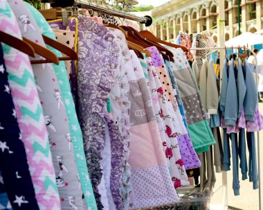 Kiev. Ukrayna. Mayıs 2018, sokak hayatı. Markette askıda asılı moda renkli giysiler var. Yakın plan..