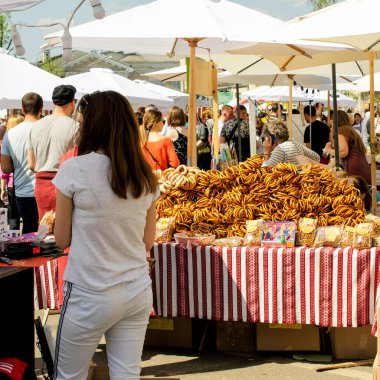 Kiev. Ukrayna. Mayıs 2018, sokak hayatı. Taze simit satışı. Büyük bir simit yığını ve sokak pazarındaki insanlar. Kare. Yakın plan..