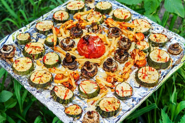 Folyodaki ızgarada kızartılmış sebze tepsisi. Yeşil çimenlerin arka planında.