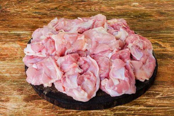 Taze çiğ tavuk eti, doğranmış ve ahşap arka planda pişirilmeye hazır. Yakın plan.
