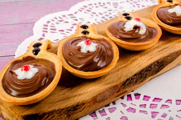 Kesme tahtasının üzerinde çikolata fındık ezmesi olan kaşık şeklinde turtalar. Üst Manzara. Yakın plan..