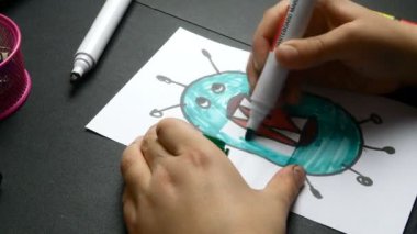 Çocuklar beyaz kağıda keçeli kalemle koronavirüs çiziyor. Karantina ve kendini izole etme süresince çocuklar için eğlence. Yakın plan..