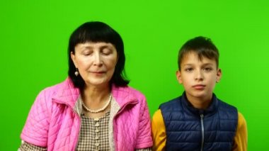 Karantina sırasında kendini izole etme. Aile içinde çocuklarla zaman geçirmek ve eğlenmek. Büyükannem ve torunum birbirlerine koruyucu tıbbi maskeler takıp çıkardılar. Krom anahtar.