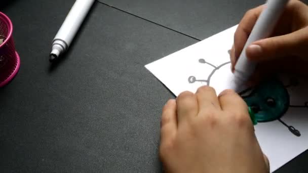 Kinderhand zeichnet Coronavirus mit Filzstift auf weißem Papier. Unterhaltung für Kinder während Quarantäne und Selbstisolierung. Nahaufnahme. — Stockvideo