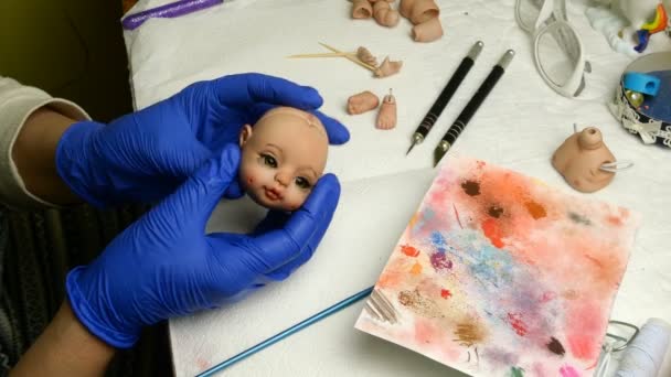 A fazer bonecas. Mestre fantoche examina produzidos a sua cabeça bonecas. Conceito de criar bonecas artesanais. Close-up . — Vídeo de Stock