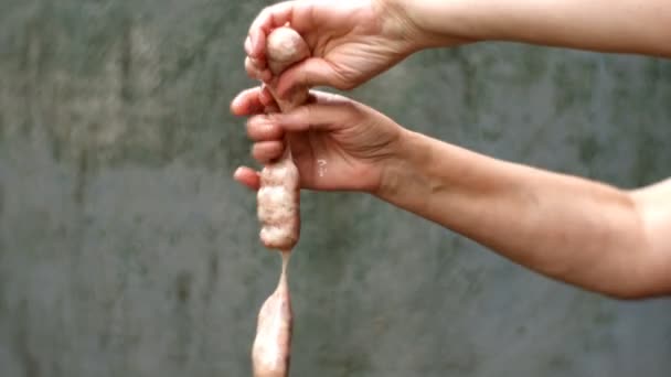 Preparations homemade sausages. Step by step. Raw bunch sausages are greased manually with fat or cooking oil and crumple for better distribution of minced meat. Close up. — Stock Video