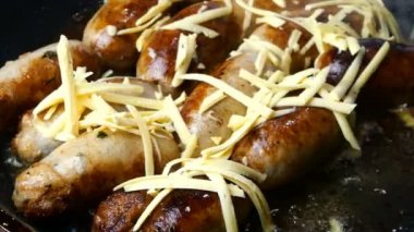 Hazırlıklar ev yapımı sosisler. Adım adım. Domuz eti ya da tavuk sosisi haşlanmış sebze ya da zeytinyağında kızartma tavasında kızartılır ve rendelenmiş peynir serpiştirilir. Ev yapımı fast food. Kapat..