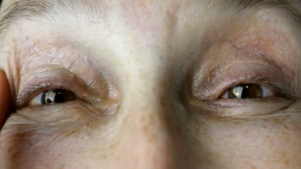 Mujer adulta madura, de etnia caucásica toca las arrugas en su cara con los dedos, mirando a la cámara. Primer plano . — Vídeos de Stock