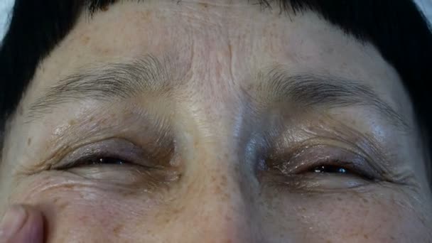 Starší dospělá žena, bělošská etnika, se prsty dotýká vrásek na tváři a dívá se do kamery. Detailní záběr. — Stock video
