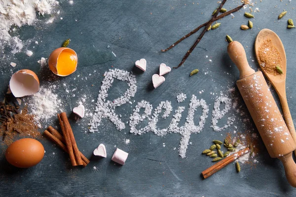 Houten keukengerei met specerijen en recept woord — Stockfoto