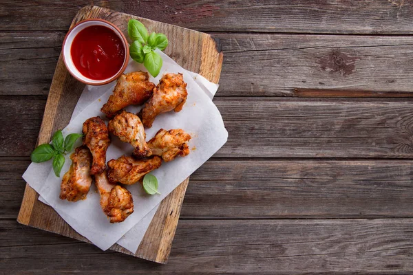 Grilled chicken drumsticks on paper — Stock Photo, Image