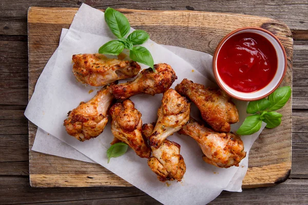 Grilled chicken drumsticks on paper — Stock Photo, Image