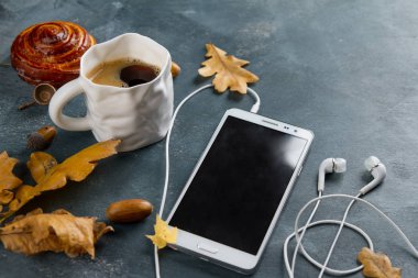 Sıcak kahve kupa ile hareket eden telefon ve kulaklık