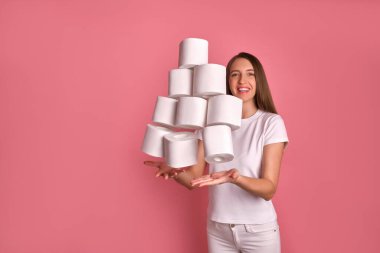 Simple yetişkin esmer kız iyi bir ruh hali içinde bir sürü tuvalet kağıdı rulosu kusuyor, mutlu bir görünüm sergiliyor, eğleniyor, virüs yüzünden uzun süre kilit altında tutulmaya hazır. Covid 19