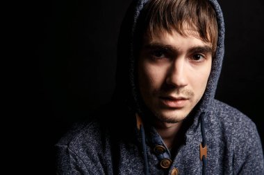 Siyah arka planda üzgün, çaresiz bir adamın portresi.