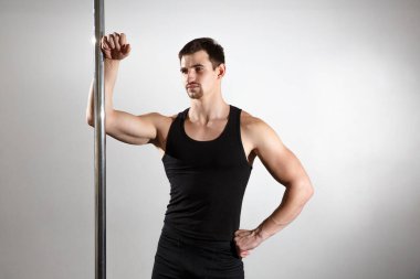 Genç, güçlü striptizci, siyah elbiseli gülümseyen adam. Beyaz arkaplan.