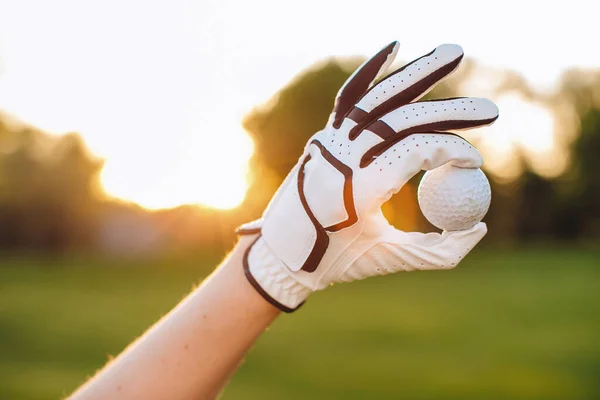 Eldivenli bir el golf topunu tutar. Golf kulübünde golf. El hareketi tamam..