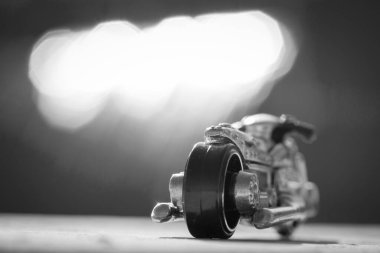 Siyah beyaz motosiklet minyatürü büyük beyaz bir bulutun altında. Geri git ve görüntüyü kapat