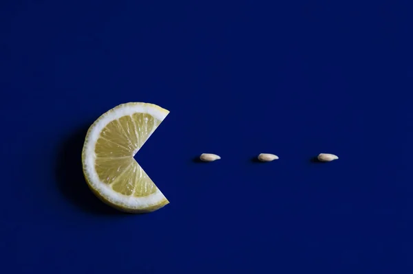 Mavi arka planda tohumları olan bir dilim limon. Kavramsal fotoğrafçılık.