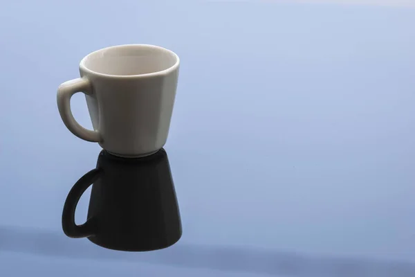 Egy Kis Csésze Fehér Kávé Tükröződik Tiszta Kék Üveg Felületén — Stock Fotó