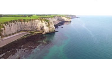 Normandiya, Fransa 'daki Cliffs Etretat. Doğanın beyaz işlerini, insansız hava aracının fotoğraflarını, kayaları, plajları, yeşil alanları, mevsimin başlarında çekilen deniz ve güneşi, yazın 4k25ftp.