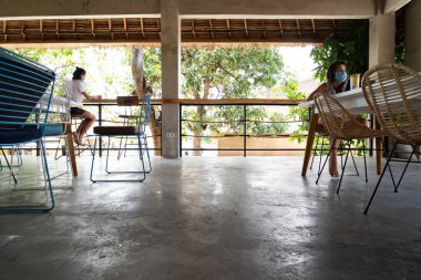 Sosyal mesafeyi koruyan ve terasta çalışan koruyucu maskeli kadınların görüntüsü 