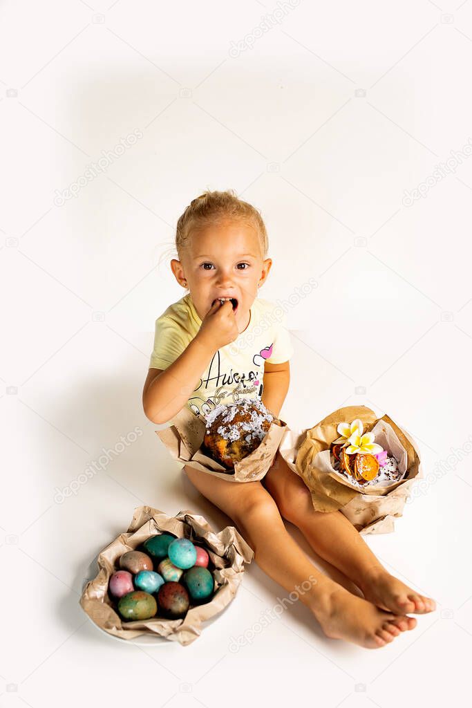 little girl siting and eating Easter pastry cake isolated on white background