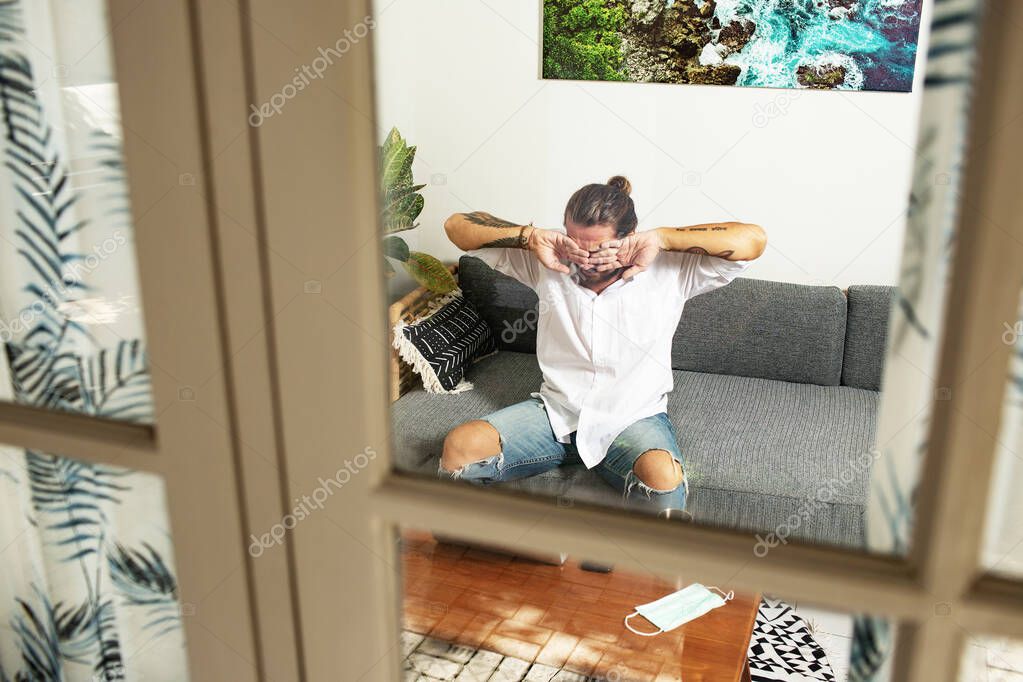 attractive young man working with laptop at home on room background