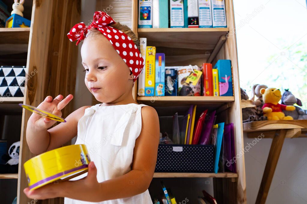 little girl playing with toys in playroom background 