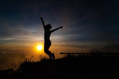 Gün batımında genç kadın silueti