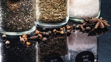 yakın plan chia tohumları, kekik ve Himalaya pembe ince tuz anason ve karanfil ile kaplanmış cam şişeler