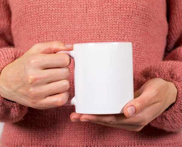 Kadın eli bardağı tutuyor.