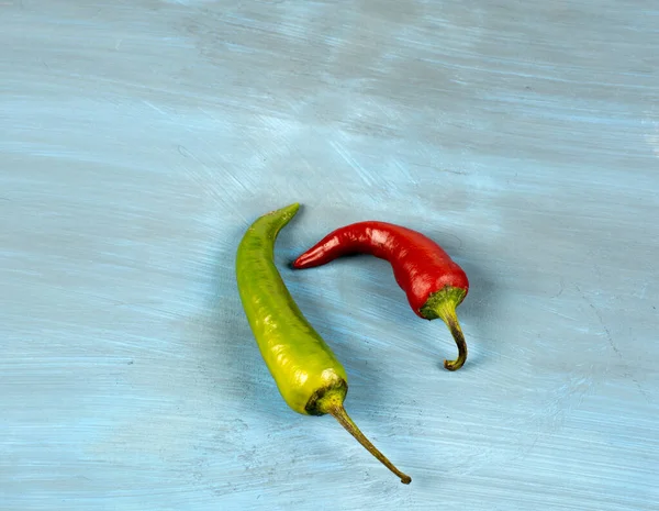 Mavi arka planda yeşil ve kırmızı biber.