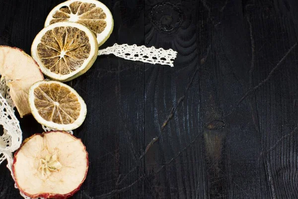 Dantel kurdeleli yanmış bir ağacın üzerinde kurumuş meyve parçaları.