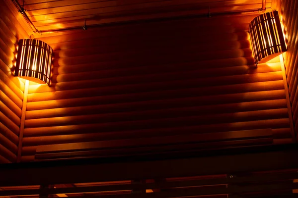 Saunanın içi sessiz sarı ışık ve güzel lambalarla dolu.