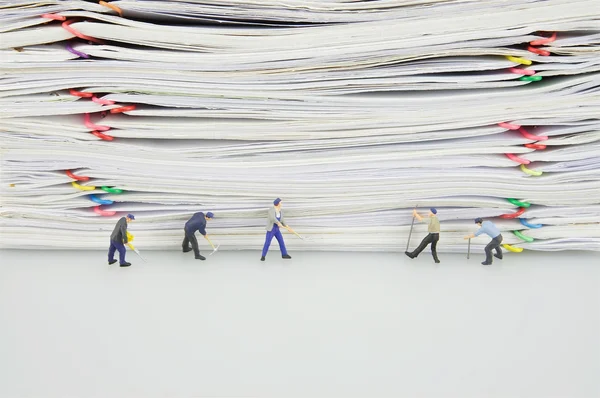 Pile overload paper and miniature people are destroyed it — Stock Photo, Image