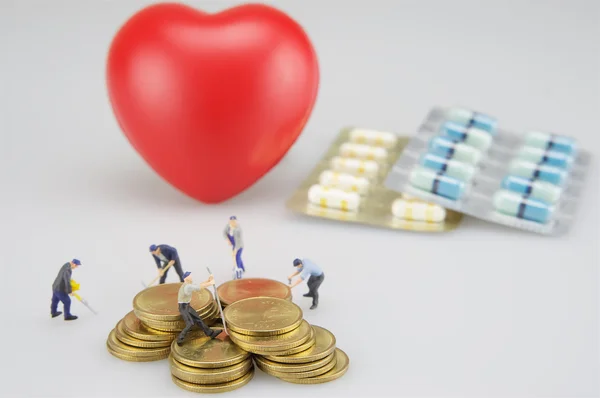 Montones de monedas y corazón con medicina — Foto de Stock