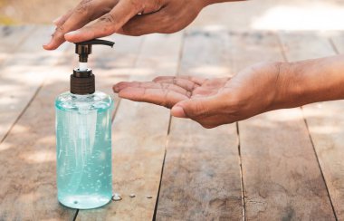 Adam el temizliğini önlemek için alkol jeli kullanıyor. 