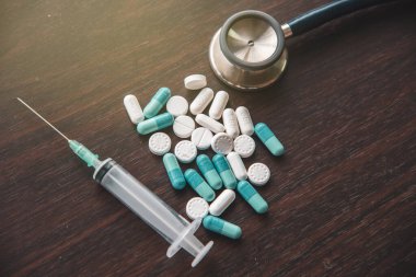 Hastanede tedavi için tıbbi ilaçlar, steteskop ve şırınga.