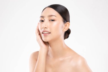 Güzel Asyalı genç bir kadın yumuşak yanaklı gülüşüne dokunuyor. Temiz ve taze tenli. Mutluluk ve neşe dolu.