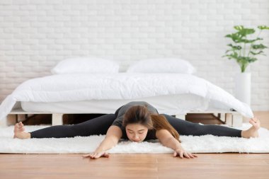 Çekici Asyalı kadın yoga pratiği yapıyor. Upavistha konasana ya da oturma açısı. Sabah uyandıktan sonra meditasyona poz veriyor.