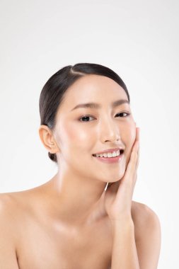 Güzel Asyalı genç bir kadın yumuşak yanaklı gülüşüne dokunuyor. Temiz ve taze tenli. Mutluluk ve neşe dolu.